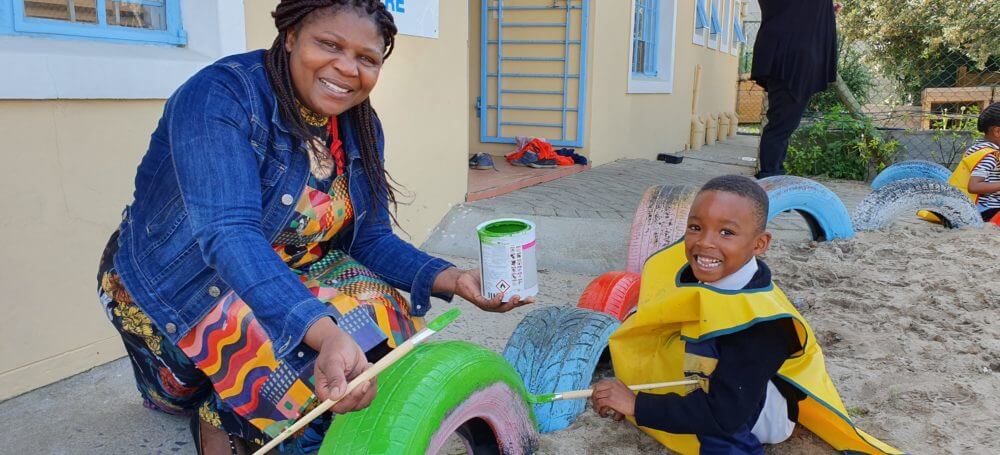 Thembeka Qubuda, principal of the pre-school doing some painting with the learners.